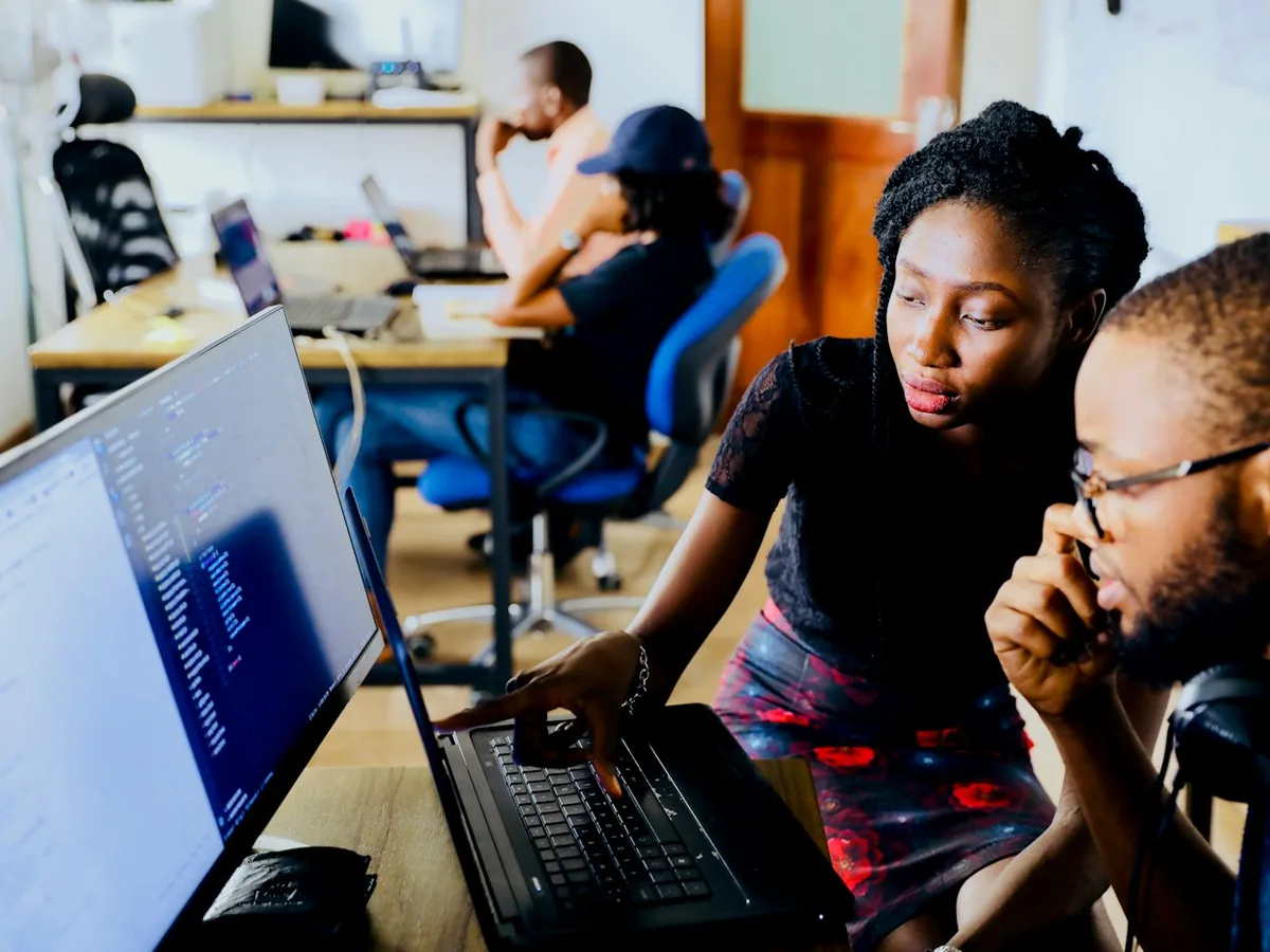 Dos personas revisan juntas la plataforma en un computador durante una reunión de evaluación